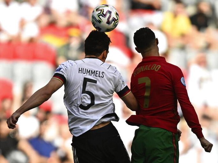 Germany's Mats Hummels, left, jumps for the ball with Portugal's Cristiano Ronaldo during the Euro 2020 soccer championship group F match between Portugal and Germany at the Football Arena stadium in Munich, Germany, Saturday, June 19, 2021. (Philipp Guelland/Pool via AP)