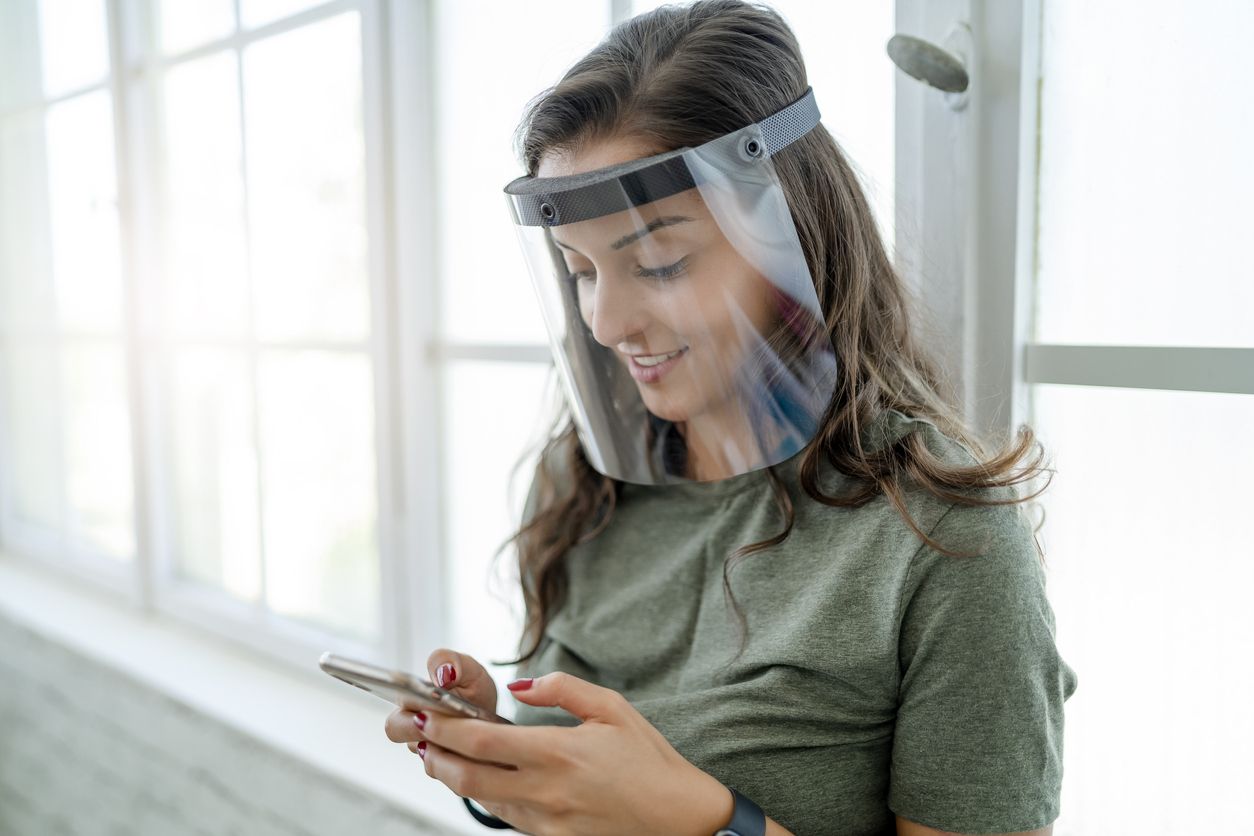 Young woman working with face shield in the office during COVID-19 pandemic
