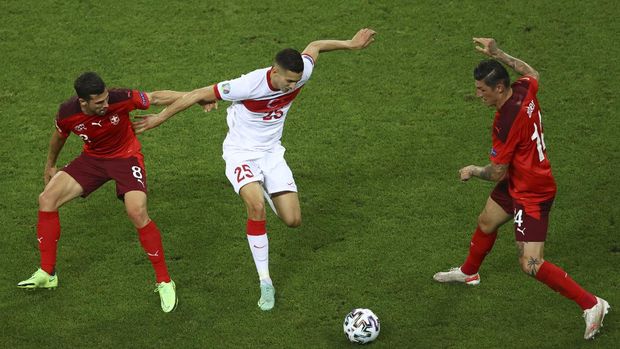 Turkey's Mert Muldur, center, tries to keep the ball as Switzerland's Remo Freuler, left, and Steven Zuber defend during the Euro 2020 soccer championship group A match between Switzerland and Turkey at the Baku Olympic Stadium in Baku, Azerbaijan, Sunday, June 20, 2021. (Naomi Baker/Pool via AP)