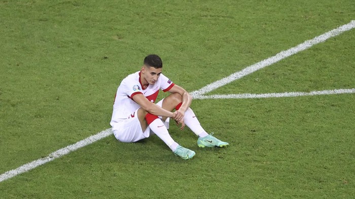 Turkeys Mert Muldur sits at the pitch after the Euro 2020 soccer championship group A match between Switzerland and Turkey at the Baku Olympic Stadium in Baku, Azerbaijan, Sunday, June 20, 2021. Switzerland won 3-1. (Naomi Baker/Pool via AP)