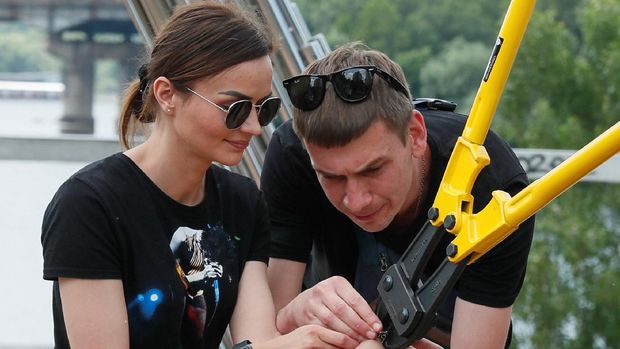 Alexandr Kudlay and Viktoria Pustovitova, who handcuffed themselves and spent 123 days together, have the chain dismantled by a representative from a Ukrainian record book in Kyiv, Ukraine June 17, 2021. The Ukrainian couple split up after 123 days handcuffed together, shedding their bonds on national TV and saying the experiment had brought home uncomfortable truths. Picture taken June 17, 2021. REUTERS/Gleb Garanich