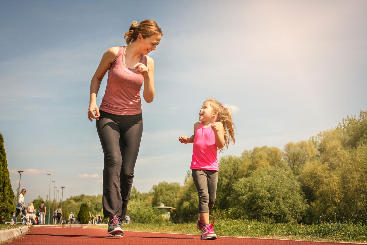 Caucasian mother and daughter jogging outdoors. Mother and daughter enjoying together.