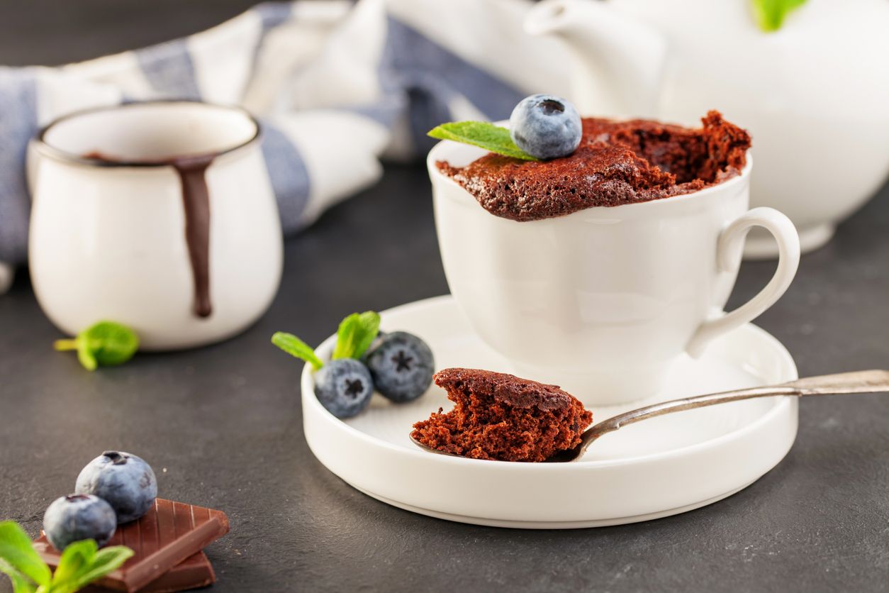 Homemade Mug Cake with chocolate and blueberries on a board