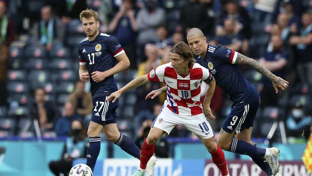 Scotland's Stuart Armstrong, Croatia's Luka Modric and Scotland's Lyndon Dykes, from left, challenge for the ball during the Euro 2020 soccer championship group D match between Croatia and Scotland at the Hampden Park Stadium in Glasgow, Tuesday, June 22, 2021.(Robert Perry/Pool via AP))
