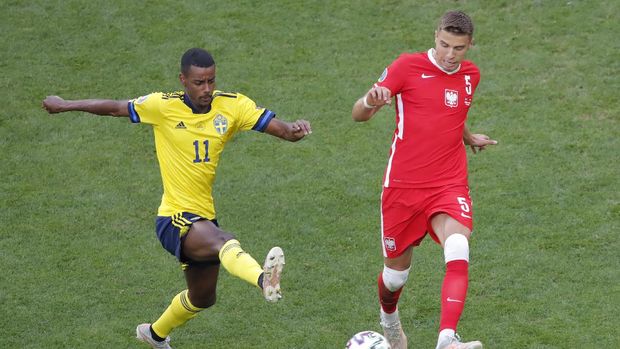 Sweden's Alexander Isak, left, challenges for the ball with Poland's Jan Bednarek during the Euro 2020 soccer championship group E match between Sweden and Poland at the Gazprom Arena stadium, in St. Petersburg, Russia, Wednesday, June 23, 2021. (Maxim Shemetov /Pool via AP)