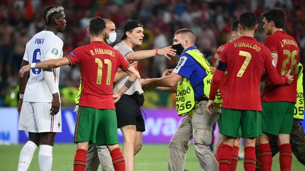 BUDAPEST, HUNGARY - JUNE 23: A pitch invader is tackled by security as he tries to get to Cristiano Ronaldo of Portugal following  the UEFA Euro 2020 Championship Group F match between Portugal and France at Puskas Arena on June 23, 2021 in Budapest, Hungary. (Photo by Franck Fife - Pool/Getty Images)