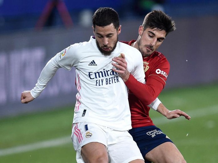 PAMPLONA, SPAIN - JANUARY 09: Eden Hazard of Real Madrid holds off Nacho Vidal of Osasuna during the La Liga Santander match between C.A. Osasuna and Real Madrid at Estadio El Sadar on January 09, 2021 in Pamplona, Spain. Sporting stadiums around Spain remain under strict restrictions due to the Coronavirus Pandemic as Government social distancing laws prohibit fans inside venues resulting in games being played behind closed doors. (Photo by Juan Manuel Serrano Arce/Getty Images)