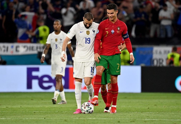 Portugal vs Prancis BUDAPEST, HUNGARY - JUNE 23: Karim Benzema of France interacts with Cristiano Ronaldo of Portugal during the UEFA Euro 2020 Championship Group F match between Portugal and France at Puskas Arena on June 23, 2021 in Budapest, Hungary. (Photo by Tibor Illyes - Pool/Getty Images)