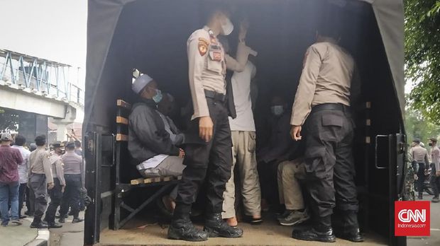 Puluhan simpatisan mantan Imam Besar FPI Rizieq Shihab yang hendak menghadiri sidang diangkut oleh aparat kepolisian di deepan Pengadilan Negeri Jakarta Timur (PN Jaktim), Kamis (24/6).