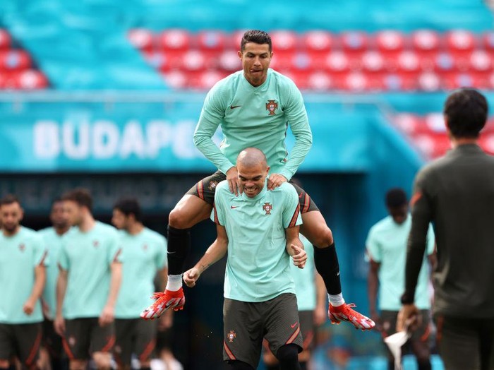 BUDAPEST, HUNGARY - JUNE 14: Cristiano Ronaldo of Portugal jumps on the back of team mate Pepe during the Portugal Training Session ahead of the UEFA Euro 2020 Group F match between Hungary and Portugal at Puskas Arena on June 14, 2021 in Budapest, Hungary. (Photo by Alex Pantling/Getty Images)
