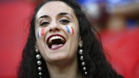 Suporter Prancis ini hadir langsung dengan merias wajahnya dengan gambar berdera negaranya. Dalam pertandingan ini, Prancis menghadapi Portugal di Puskas Arena, Budapest pada 23 Juni 2021. Franck Fife, Pool photo via AP.