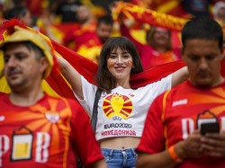Suporter cantik dari Macedonia Utara memberikan semangat kepada para pemain dengan membentangkan bendera negaranya. AP Photo/Vadim Ghirda, Pool.