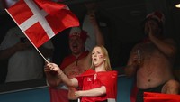 Tak mau kalah, suporter cantik asal Denmark juga hadir dalam pertandingan antara timnas negaranya melawan Rusia di Stadion Parken, Kopenhagen pada 21 Juni 2021. Dia terus mengibarkan bendera negaranya sepanjang pertandingan. Jonathan Nackstrand/Pool via AP.