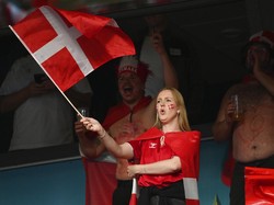 Tak mau kalah, suporter cantik asal Denmark juga hadir dalam pertandingan antara timnas negaranya melawan Rusia di Stadion Parken, Kopenhagen pada 21 Juni 2021. Dia terus mengibarkan bendera negaranya sepanjang pertandingan. Jonathan Nackstrand/Pool via AP.