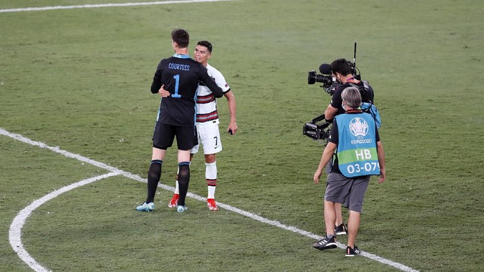 SEVILLE, SPAIN - JUNE 27: Cristiano Ronaldo of Portugal is consoled by Thibaut Courtois of Belgium as they are filmed by a TV camera operator after the UEFA Euro 2020 Championship Round of 16 match between Belgium and Portugal at Estadio La Cartuja on June 27, 2021 in Seville, Spain. (Photo by Jose Manuel Vidal - Pool/Getty Images)