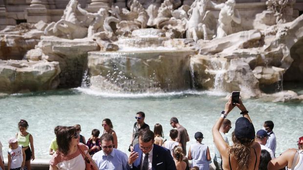 Pernah Terpuruk Karena Covid, Kini Italia Jadi Zona Bebas Masker People gather in front of the Trevi fountain in Rome, Monday, June 28, 2021. Italians took off their face masks and breathed a huge sigh of relief on Monday as the government-imposed requirement on mask wearing outdoors was lifted. Italian Health Minister Roberto Speranza made the decision last week to lift the outdoor mask-wearing requirement on advice from Italy’s Scientific Technical Committee (CTS) that made the decision based on the stabilisation of Italy Covid-19 indicators. (Cecilia Fabiano/LaPresse via AP)