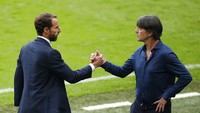 Loew melakukan salam komando dengan Gareth Southgate. Entah apa sebelum itu Loew sudah cuci tangan terlebih dulu. (Foto: AP/John Sibley)