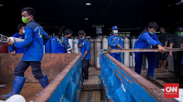 Bantuan Distribusi Tabung Oksigen ke RS Rujukan Covid Petugas Suku Dinas (Sudin) Sumber Daya Air (SDA) Jakarta Pusat memindahkan tabung oksigen kedalam truk di tempat pengisian oksigen Aneka Gas Industri di kawasan Cakung, Jakarta Timur, Kamis (1/6/2021). Pemprov DKI Jakarta mengerahkan kendaraan dari berbagai Satuan Kerja Perangkat Daerah (SKPD) atau kedinasan di DKI Jakarta untuk mendistribusikan oksigen ke berbagai rumah sakit rujukan pasien Covid-19. Hal tersebut sebagai upaya mempercepat sirkulasi tabung oksigen yang sempat mengalami kelangkaan beberapa hari lalu akibat dari peningkatan harian kasus Covid-19 di DKI Jakarta. (CNN Indonesia/ Adi Maulana)