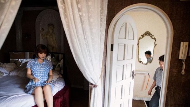 In this picture taken on June 14, 2017, physiotherapist Masayuki Ozaki (R) prepares to check out of a love hotel after spending a night with his silicone sex doll Mayu in Yachimata, Chiba prefecture. - Around 2,000 of the life-like dolls -- which cost around 6,000 USD and come with adjustable fingers, removable head and life-like genitals -- are sold each year in Japan, according to industry insiders. (Photo by Behrouz MEHRI / AFP) / TO GO WITH Japan-social-lifestyle,FEATURE by Alastair HIMMER