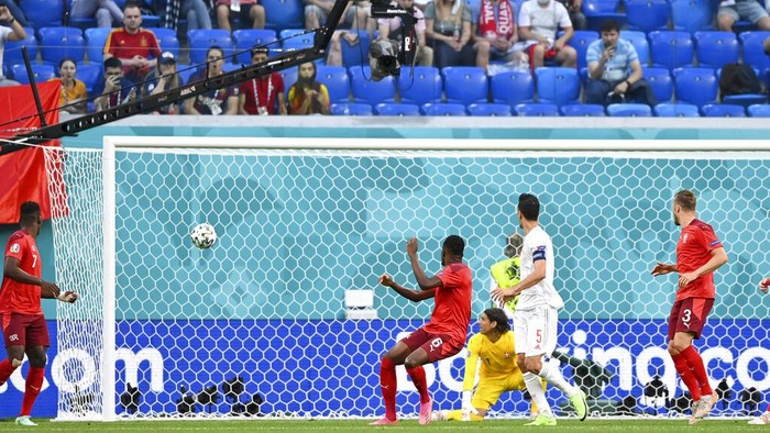 The ball shot by Spains Jordi Alba goes into the net for Spain to score its opening goal during the Euro 2020 soccer championship quarterfinal match between Switzerland and Spain, at the Saint Petersburg stadium in Saint Petersburg, Friday, July 2, 2021. (Kirill Kudryavtsev, Pool via AP)