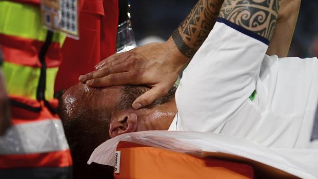 Italy's Leonardo Spinazzola covers his face after injuring during the Euro 2020 soccer championship quarterfinal match between Belgium and Italy at at the Allianz Arena in Munich, Germany, Friday, July 2, 2021. (AP Photo/Philipp Guelland, Pool Photo via AP)