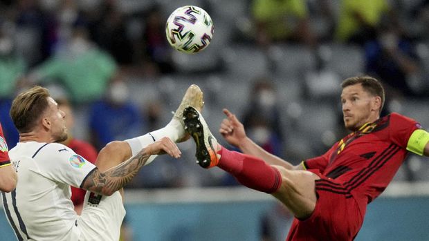 Italy's Ciro Immobile, left, and Belgium's Jan Vertonghen challenge for the ball during the Euro 2020 soccer championship quarterfinal match between Belgium and Italy at the Allianz Arena stadium in Munich, Germany, Friday, July 2, 2021. (AP Photo/Matthias Schrader, Pool)
