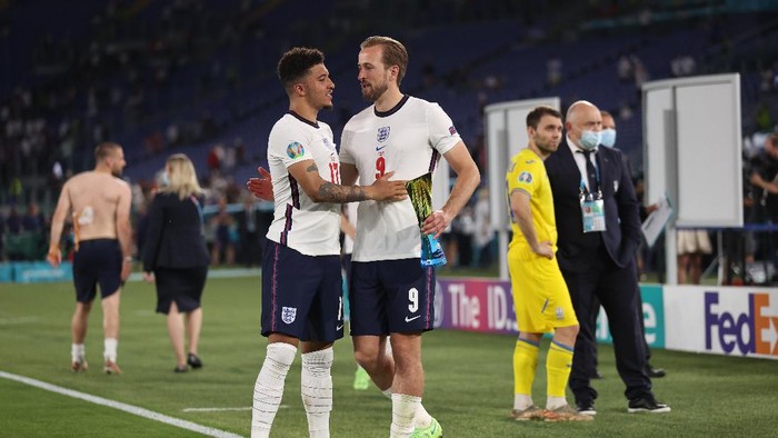 Englands Jadon Sancho, left, congratulates team mate Harry Kane after he is awarded 
