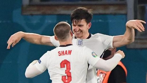 England's defender Harry Maguire (back) celebrates with England's defender Luke Shaw after scoring the second goal during the UEFA EURO 2020 quarter-final football match between Ukraine and England at the Olympic Stadium in Rome on July 3, 2021. (Photo by ALBERTO LINGRIA / POOL / AFP)