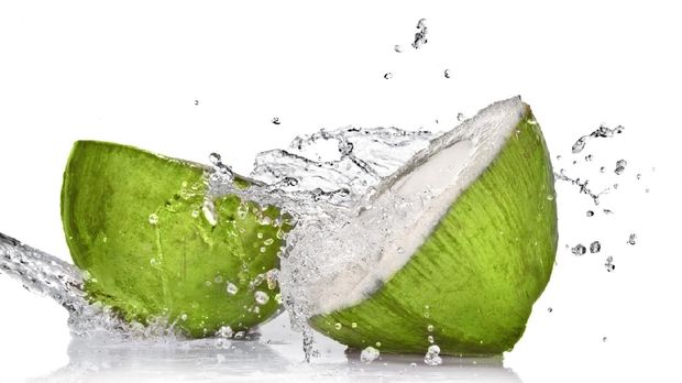 green coconut with water splash on white