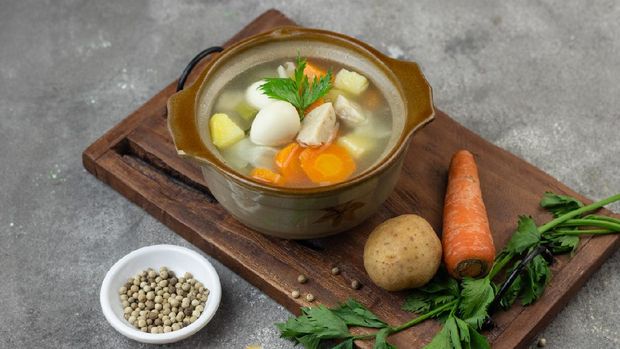 Sop Sayur or Indonesian vegetables soup, made from carrot, cabbage, potato, meatball and quail eggs. Served on ceramic bowl. Copy space for text background.