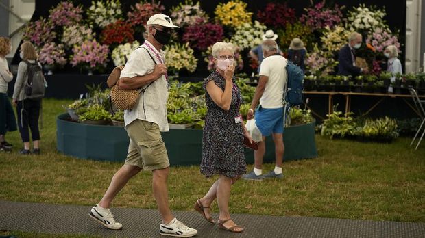 People wear face coverings to curb the spread of coronavirus as requested whilst inside the Floral Marquee during the press day for the RHS (Royal Horticultural Society) Hampton Court Palace Garden Festival in East Molesey, south west London, Monday, July 5, 2021. The annual event was cancelled last year due to Britain's Coronavirus outbreak. (AP Photo/Matt Dunham)