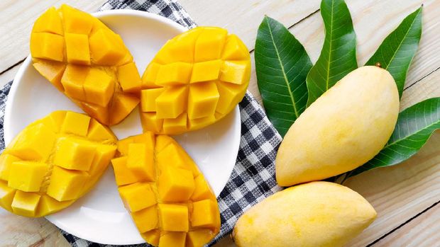 Mango yellow on white plate with wooden background. fruit food tropical thailand concept.