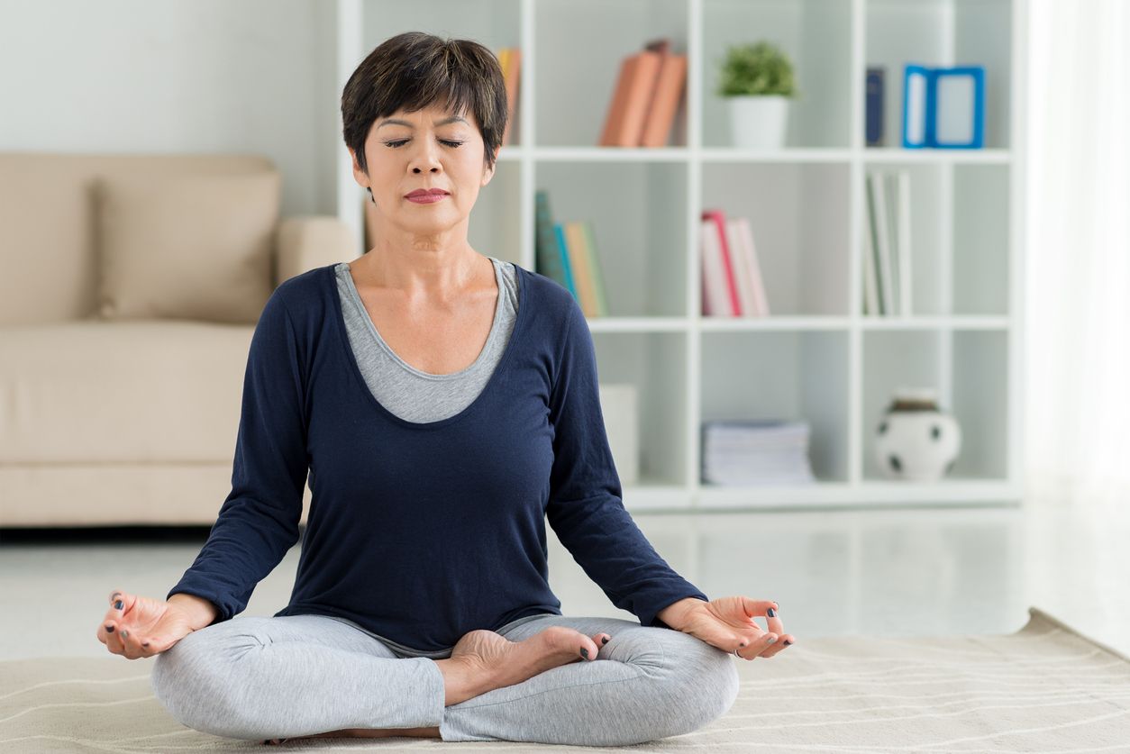 Mature woman sitting on the floor in lotus position