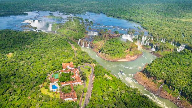 pemandangan Taman Nasional Iguazu Declared a world heritage in 1984, this marvel of nature with 275 waterfalls formed by the Iguazu River between Brazil and Argentina represents the largest set of waterfalls in the world. Its biggest drop known as the Devil's Throat, reaches approximately 150 meters wide and 80 meters high.