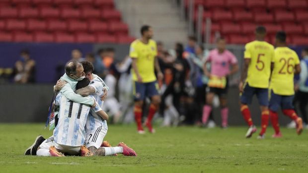 Argentina's players embrace with a member of the team after defeating Colombia in a penalty shootout during a Copa America semifinal soccer match at the National stadium in Brasilia, Brazil, Wednesday, July 7, 2021. (AP Photo/Eraldo Peres)
