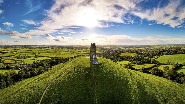 Glastonbury Tor near Glastonbury in the English county of Somerset, topped by the roofless St Michael's Tower, UK