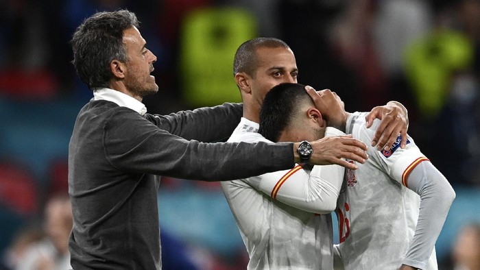 Spains manager Luis Enrique, left, comforts Spains Thiago, center, and Spains Pedri during the Euro 2020 soccer championship semifinal match between Italy and Spain at Wembley Stadium in London, Tuesday, July 6, 2021. (Andy Rain/Pool via AP)