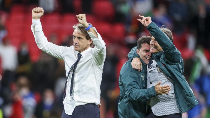 Italys manager Roberto Mancini, left, celebrates after winning the Euro 2020 soccer championship semifinal match against Spain at Wembley stadium in London, England, Tuesday, July 6, 2021. (Carl Recine/Pool Photo via AP)
