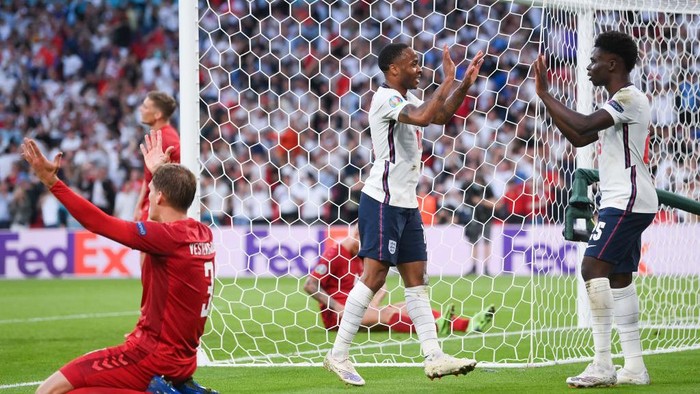LONDON, ENGLAND - JULY 07: Raheem Sterling of England celebrates with Bukayo Saka after their sides first goal, an own goal by Simon Kjaer of Denmark (not pictured) during the UEFA Euro 2020 Championship Semi-final match between England and Denmark at Wembley Stadium on July 07, 2021 in London, England. (Photo by Laurence Griffiths/Getty Images)