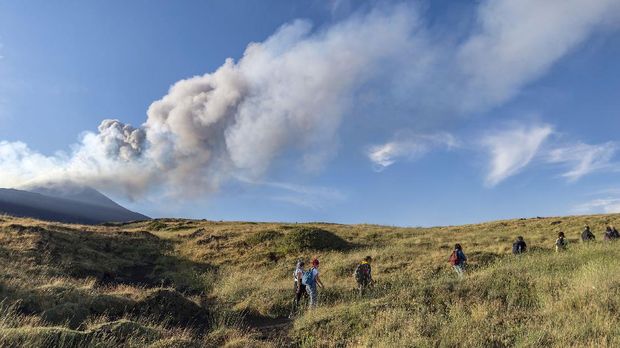 Gunung Etna Kembali Erupsi Hikers walk on a path as Mt. Etna, Europe's largest active volcano, erupts in the background, in the Bove Valley of Etna Park, on the eastern slope of Mt. Etna, in Sicily, southern Italy, Sunday, July 7, 2021. Since Feb. 16, 2021, Mt. Etna has begun a series of eruptive episodes. (AP Photo/Salvatore Allegra)