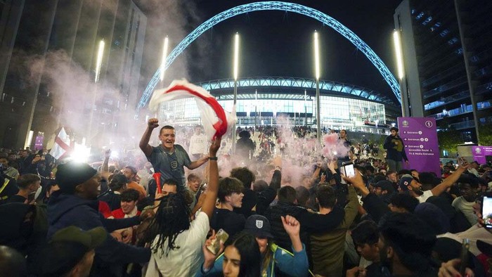 Fans celebrate outside Wembley Stadium after England qualified for the Euro 2020 final where they will face Italy on Sunday, following the Euro 2020 soccer championship semifinal match between England and Denmark, in London, England, Wednesday, July 7, 2021. (Zac Goodwin/PA via AP)