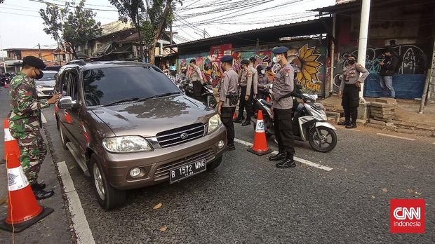 Petugas kepolisian membuat jalur darurat dan khusus tenaga kesehatan (nakes) di pos penyekatan Lenteng Agung, Jakarta Selatan pada hari kelima pelaksanaan PPKM Darurat.