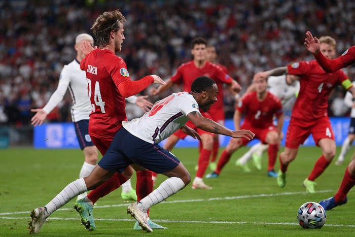 Raheem Sterling England's Raheem Sterling, left, is fouled by Denmark's Mathias Jensen and a penalty is awarded during the Euro 2020 soccer semifinal match between England and Denmark at Wembley stadium in London, Wednesday, July 7, 2021. (Laurence Griffiths/Pool Photo via AP)