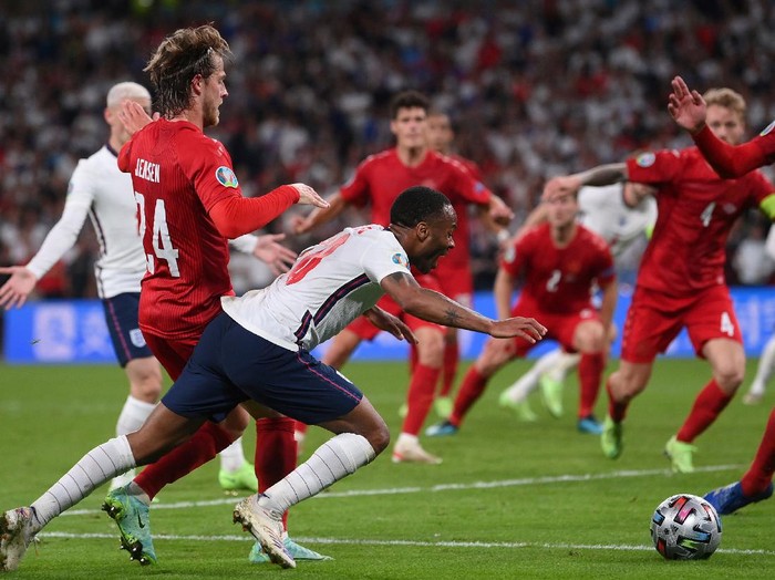 England's Raheem Sterling, left, is fouled by Denmark's Mathias Jensen and a penalty is awarded during the Euro 2020 soccer semifinal match between England and Denmark at Wembley stadium in London, Wednesday, July 7, 2021. (Laurence Griffiths/Pool Photo via AP)