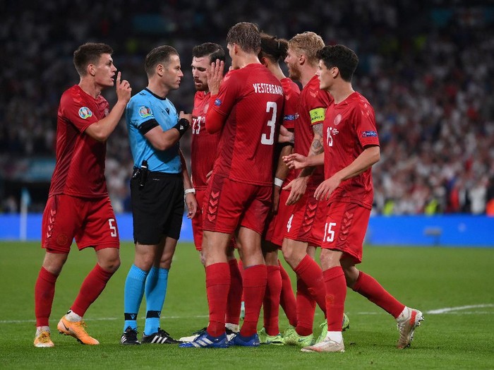 Denmark players argue with referee Danny Makkelie after he awarded a penalty to England's Raheem Sterling during the Euro 2020 soccer semifinal match between England and Denmark at Wembley stadium in London, Wednesday, July 7, 2021. (Laurence Griffiths/Pool Photo via AP)