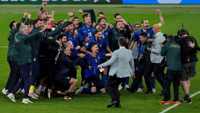 Italys coach Roberto Mancini (C) and Italys players celebrate after winning the UEFA EURO 2020 semi-final football match between Italy and Spain at Wembley Stadium in London on July 6, 2021. (Photo by Matt Dunham / POOL / AFP)