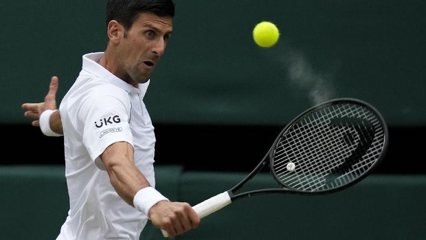 Serbia's Novak Djokovic plays a return to Canada's Denis Shapovalov during the men's singles semifinals match on day eleven of the Wimbledon Tennis Championships in London, Friday, July 9, 2021. (AP Photo/Kirsty Wigglesworth)