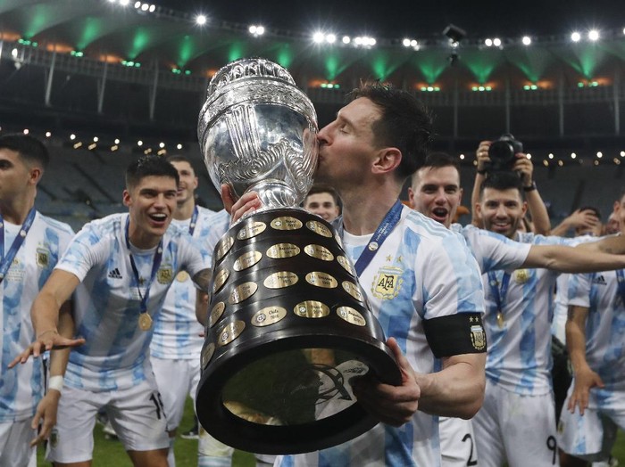 Argentina's Lionel Messi kisses the trophy after beating Brazil 1-0 in the Copa America final soccer match at Maracana stadium in Rio de Janeiro, Brazil, Saturday, July 10, 2021. (AP Photo/Bruna Pardo)