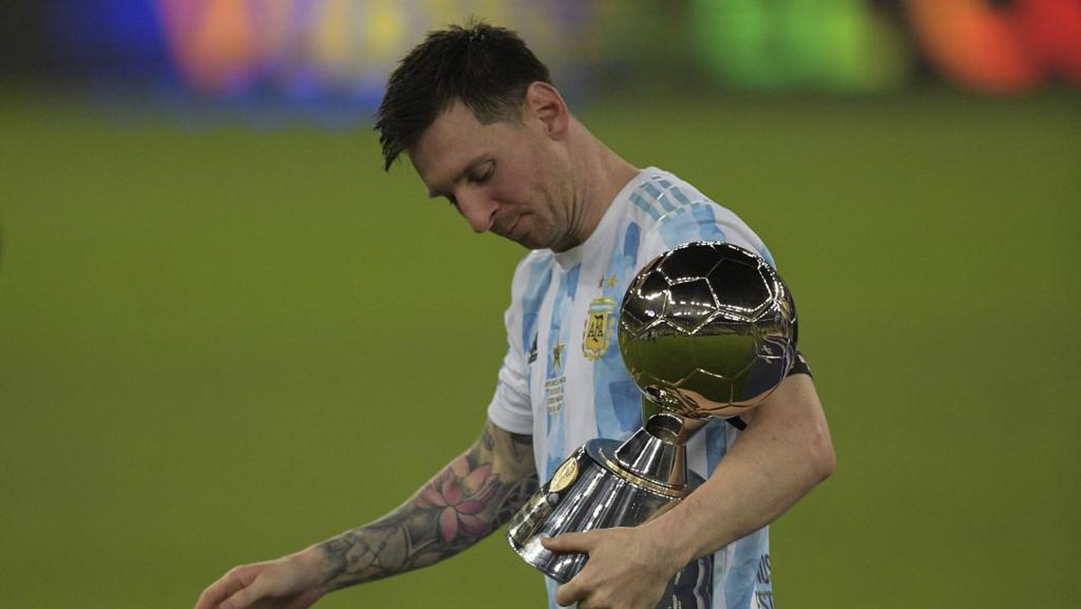 Striker Lionel Messi menenteng trofi pemain terbaik Copa America 2021. (Foto: CARL DE SOUZA/AFP)