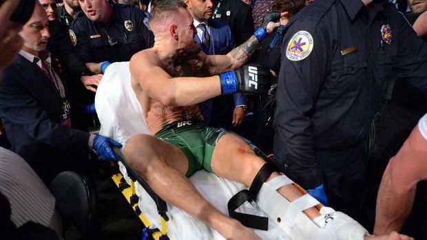 Jul 10, 2021; Las Vegas, Nevada, USA; Conor McGregor is carried off a stretcher following an injury suffered against Dustin Poirier during UFC 264 at T-Mobile Arena. Mandatory Credit: Gary A. Vasquez-USA TODAY Sports